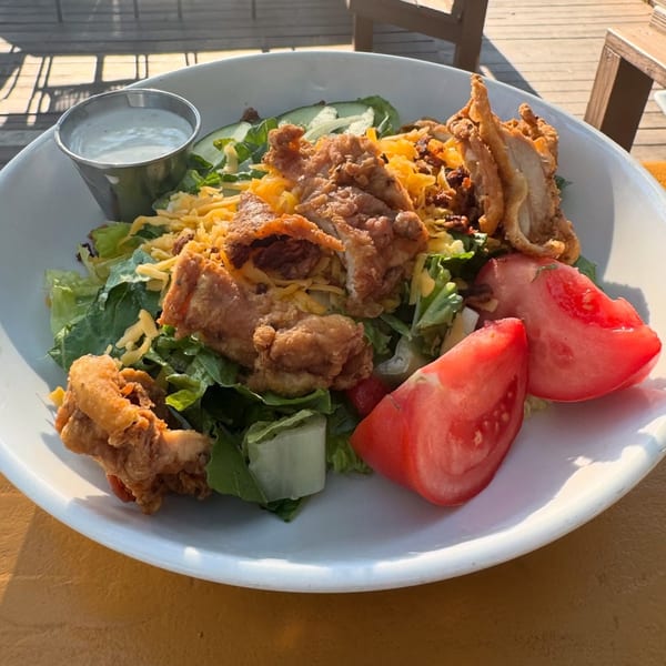 Southern Fresh fried chicken salad with lettuce, cheese, tomatoes, and a side of dressing.